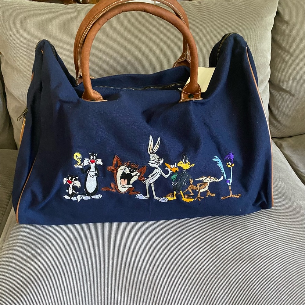Warner Brothers, canvas, cotton duffel with leather straps, and trim.